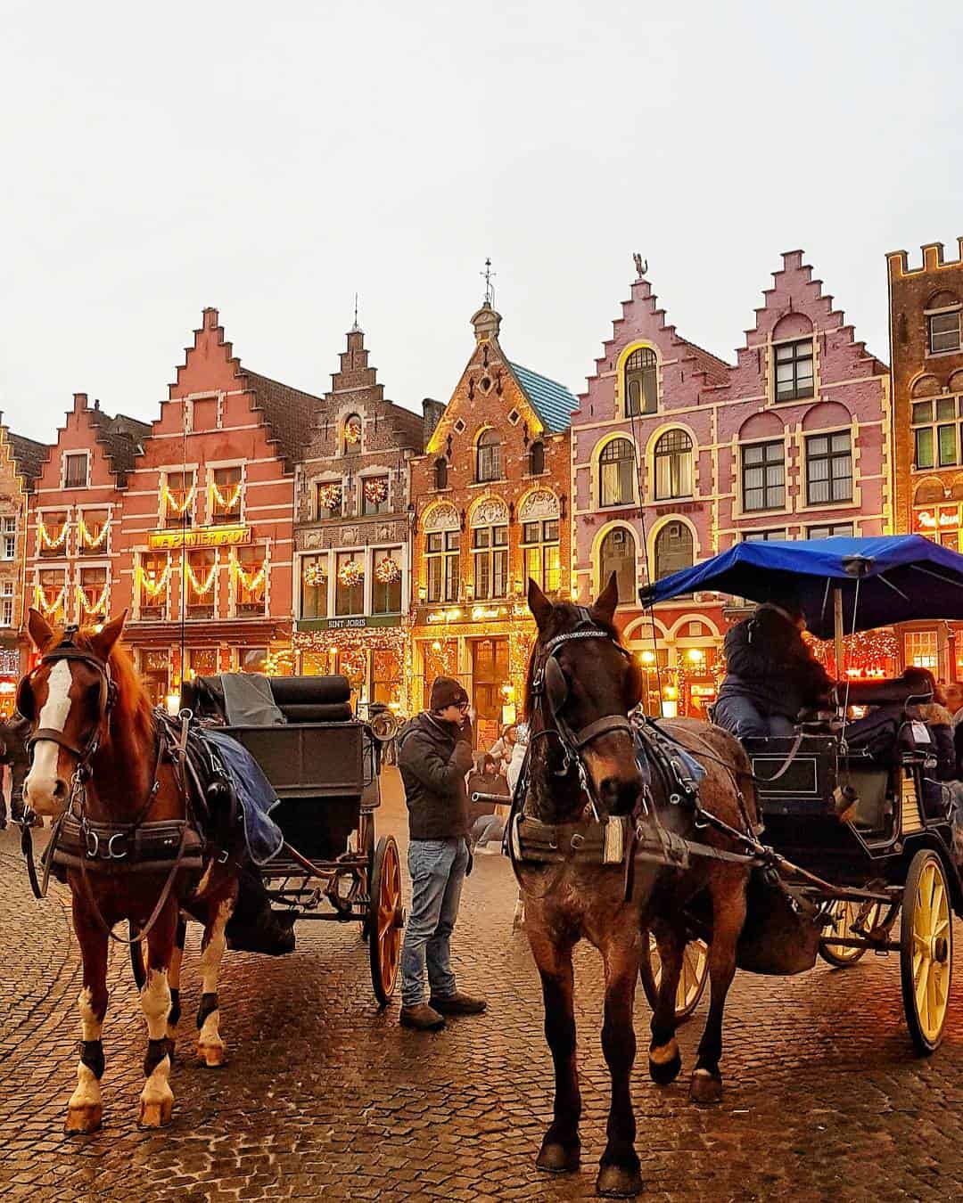 Brightly coloured historic buildings in Berlin's Mitte district with horse-drawn carriages.