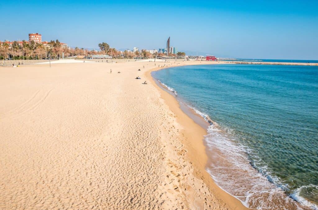Beach at St Christopher’s Berlin - Mitte with sandy shores and city skyline in the background.
