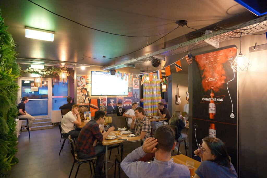 Cozy interior of Mitte Hostel Berlin with guests enjoying drinks and conversation.