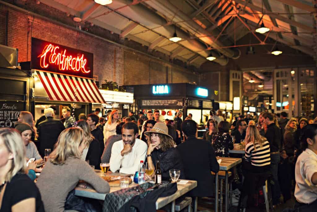 Vibrant indoor scene at Mitte Hostel, Berlin with guests socialising and enjoying drinks.