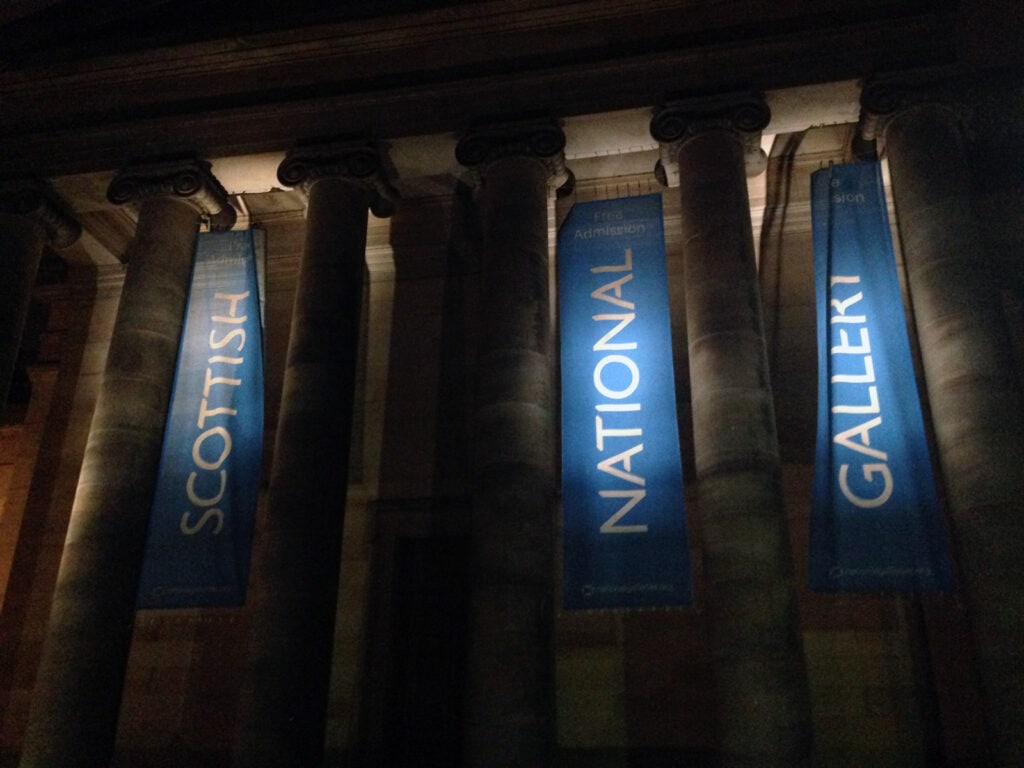 Interior view of columns with Scottish, National, and Gallery banners at Mitte Hostel, Berlin.