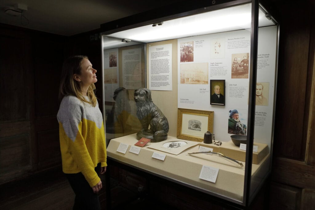 Visitor viewing historical exhibits at St Christopher’s Berlin - Mitte hostel museum.