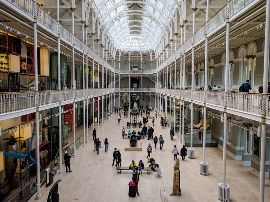 Historic Berlin shopping arcade interior with glass ceiling and visitors.