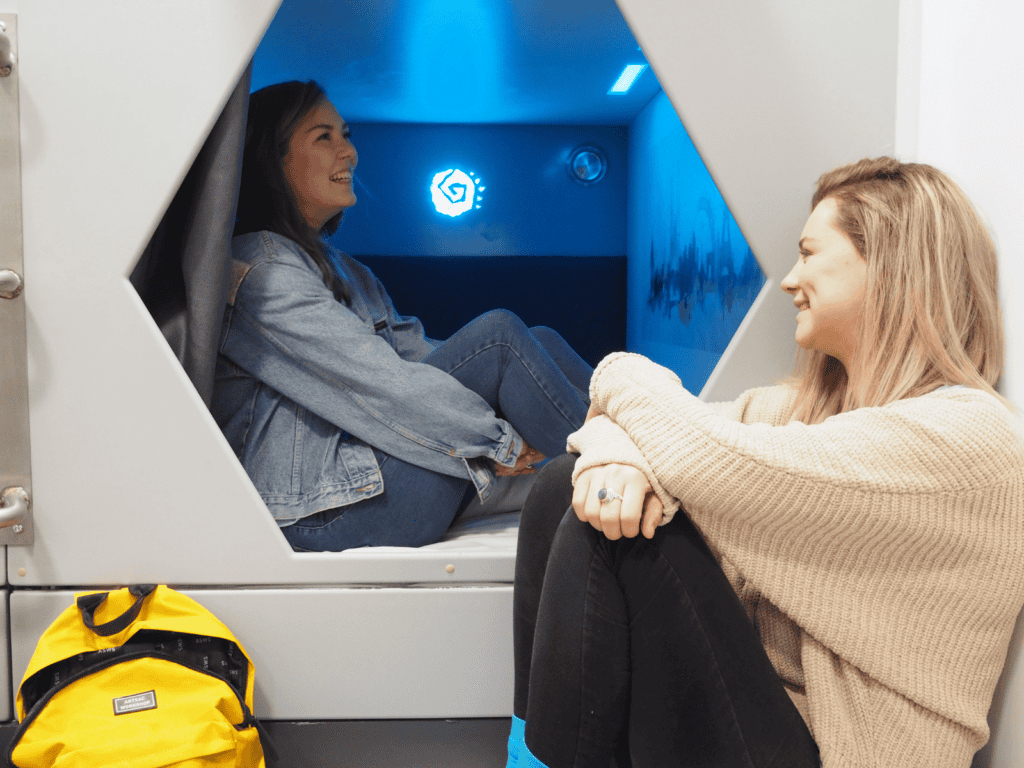 Two women enjoying a private pod at St Christopher’s Mitte Hostel, Berlin.