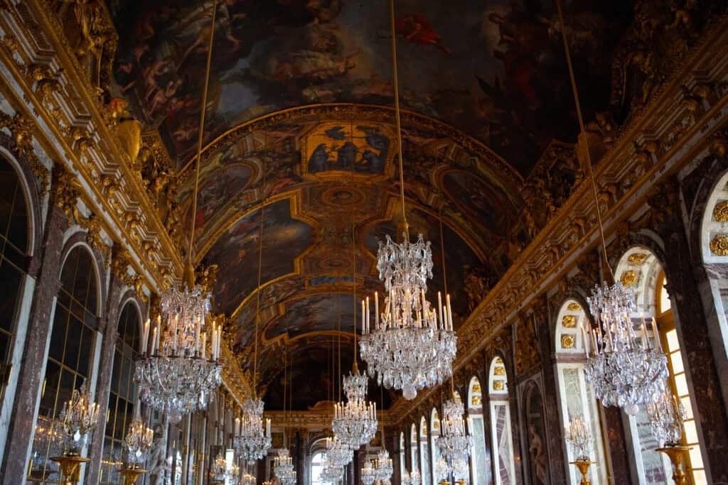 Luxurious palace interior featuring ornate chandeliers and detailed ceiling artwork in Berlin.