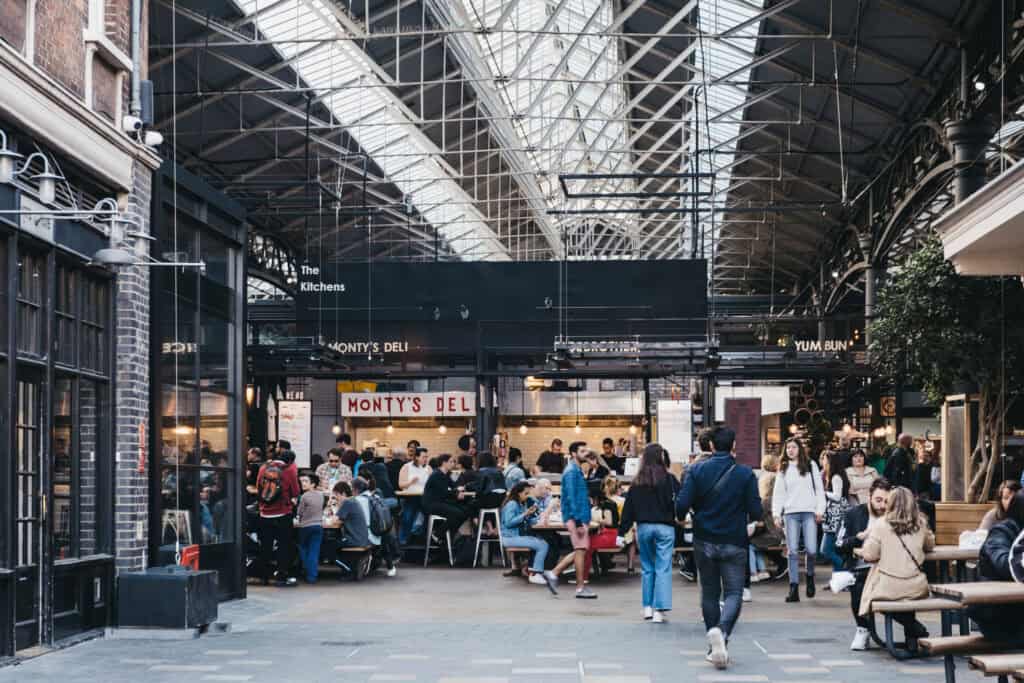 Indoor market at St Christopher’s Berlin - Mitte with diverse food stalls and visitors.
