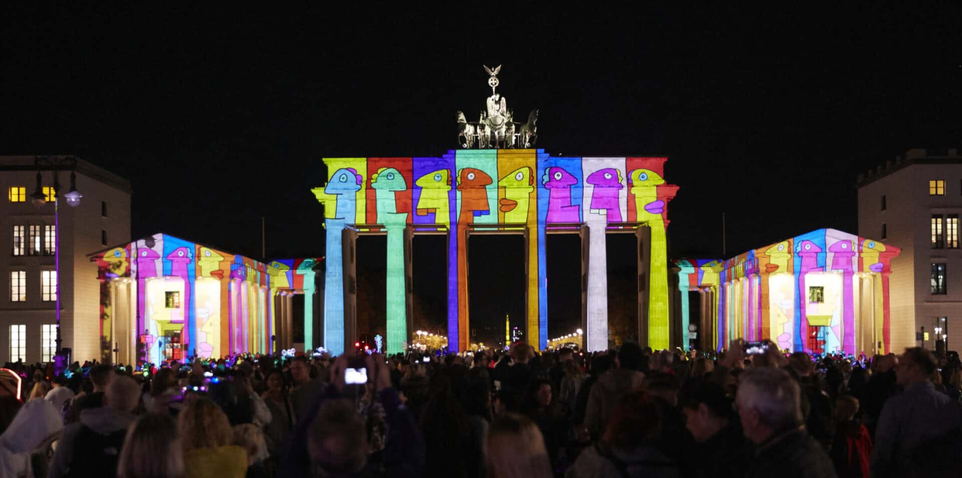 Brandenburg Gate illuminated with colourful light projections during a night event in Berlin.