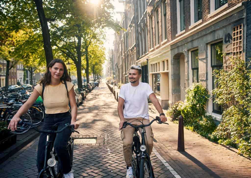 Bright young people cycling in Berlin Mitte neighbourhood.