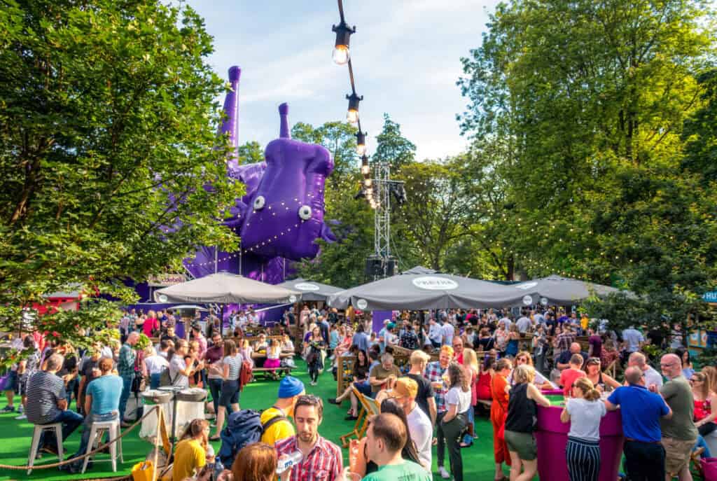 Outdoor event at Mitte Hostel Berlin with a large purple inflatable sculpture and many guests enjoyi.