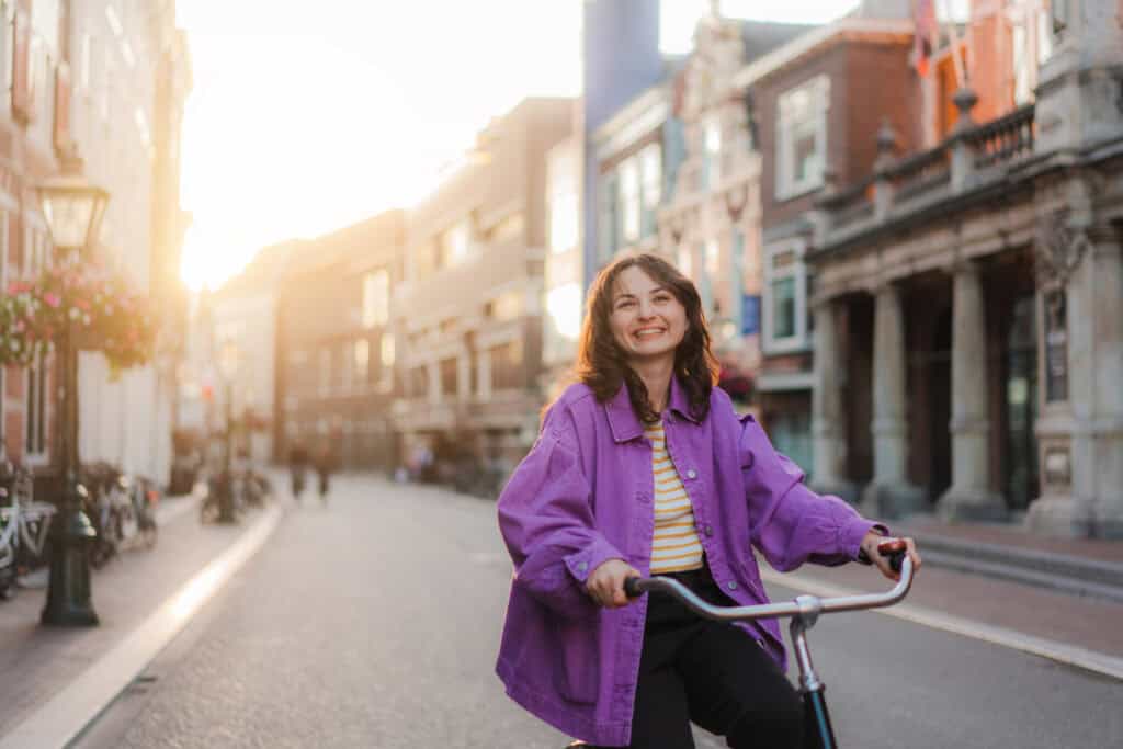 Young woman riding a bicycle in Berlin's Mitte district during sunset.