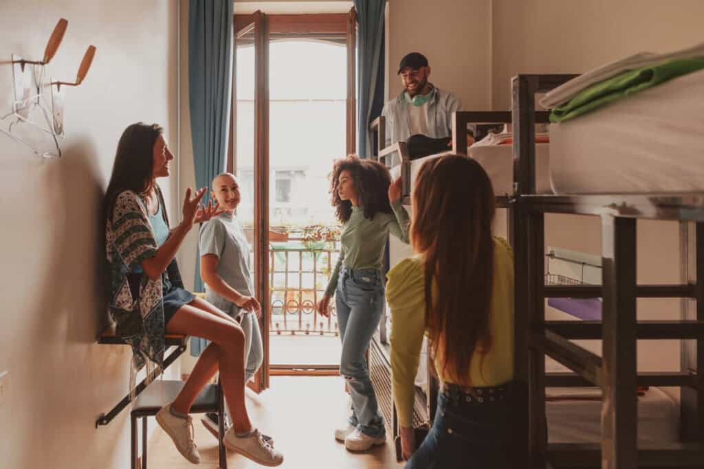 Group of young travellers chatting in a hostel room at St Christopher’s Berlin - Mitte.