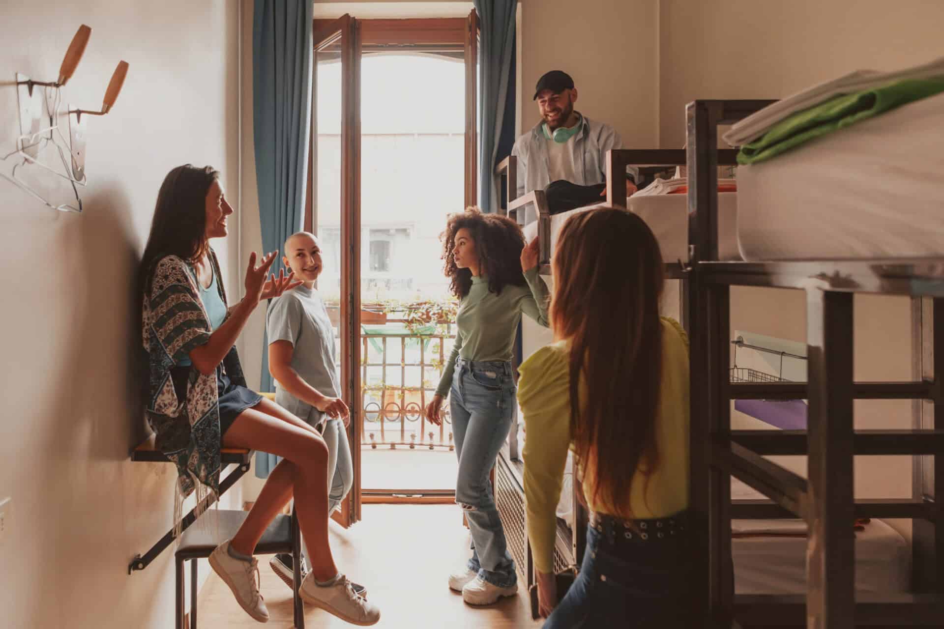 Group of young travellers chatting in a hostel room at St Christopher’s Berlin - Mitte.