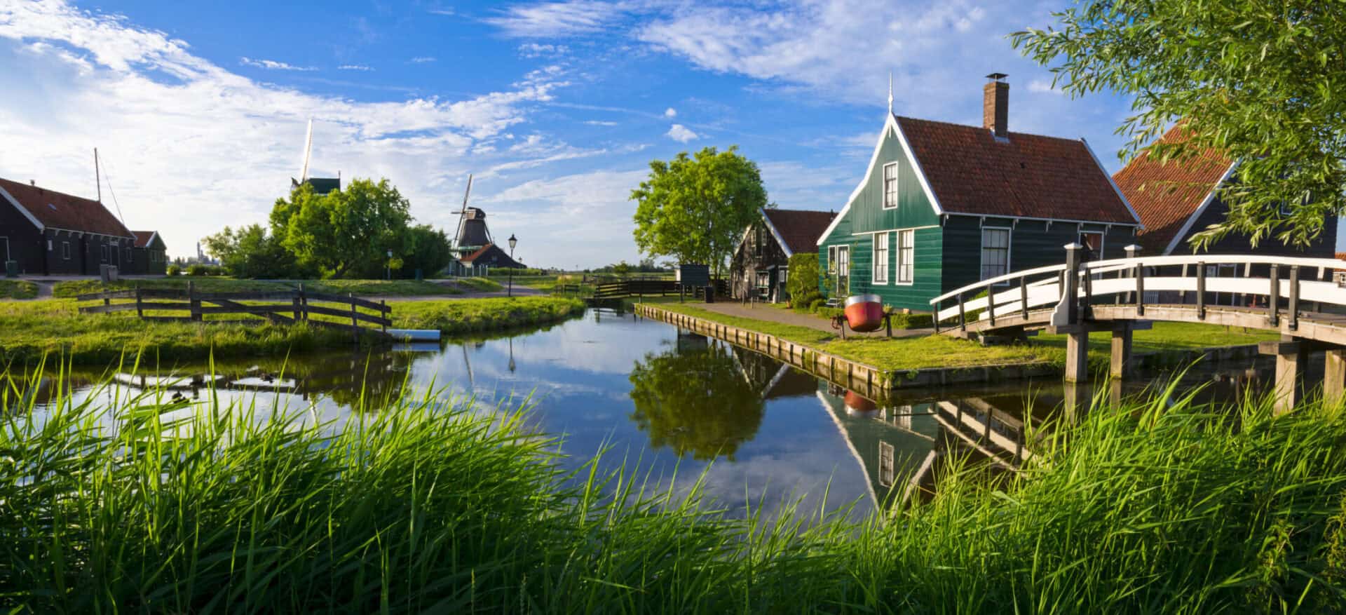 Scenic view of traditional houses and canal in a peaceful Dutch village setting.