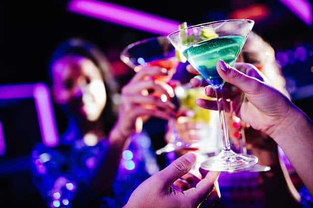 Group of friends enjoying colourful cocktails at a lively bar in Berlin Mitte.