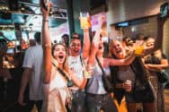 Lively group of friends enjoying drinks and dancing at a nightclub, capturing fun and excitement in.