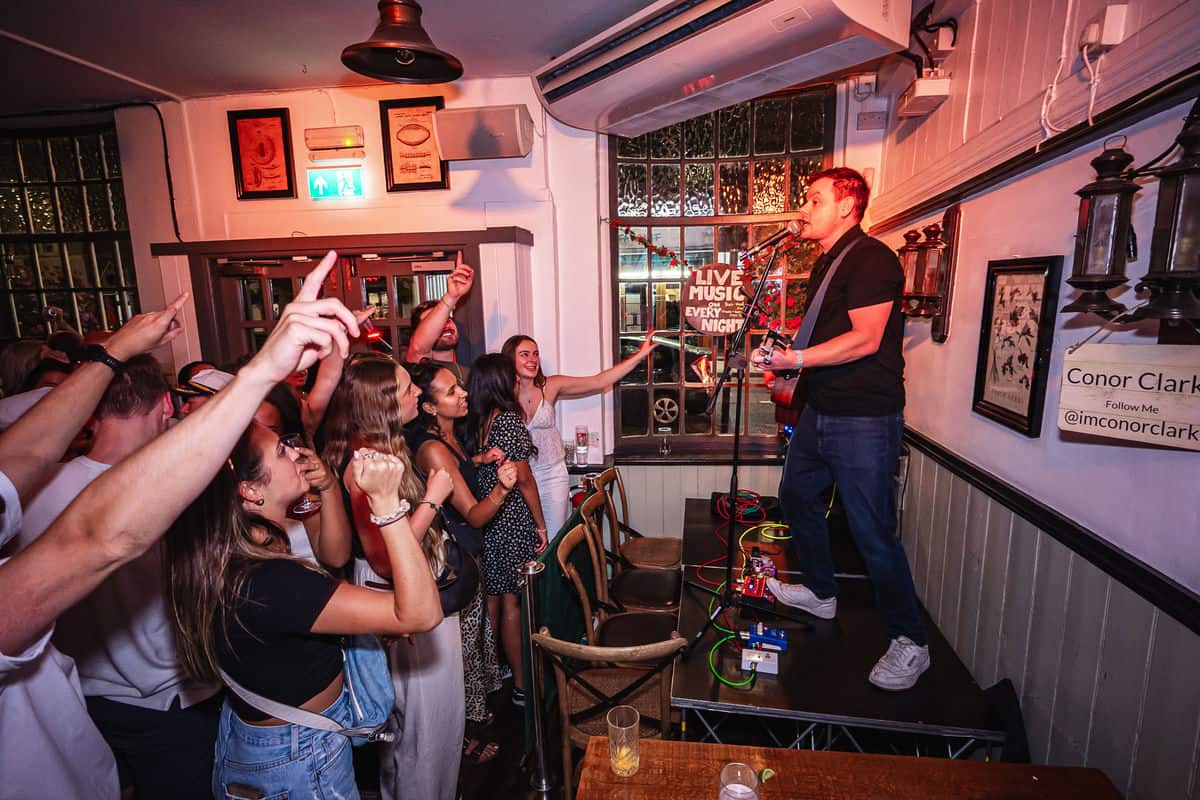 Live music performance at St Christopher's pub with an engaged crowd.
