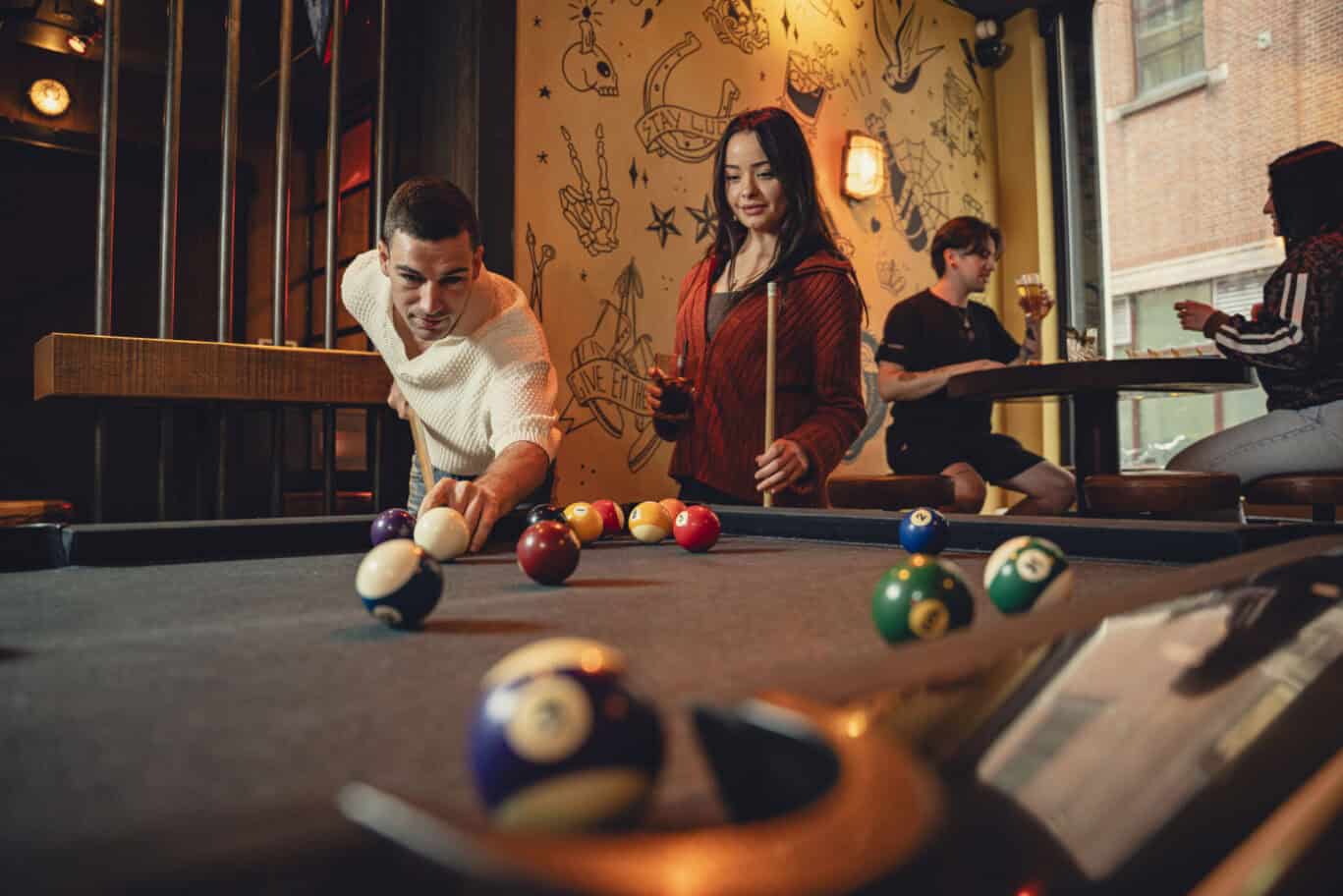 A group of friends enjoying a game of pool at St Christopher's, a lively venue with a vibrant atmosp.