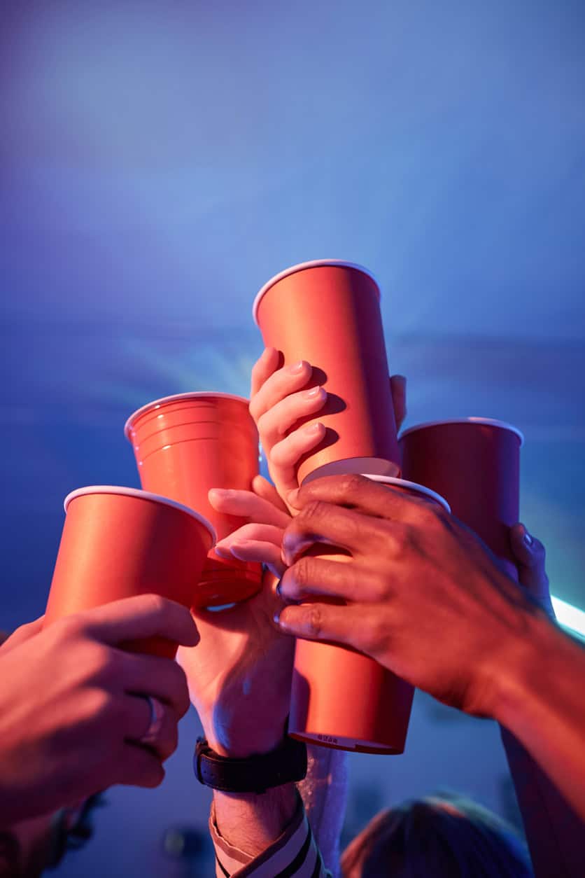 Group of people raising orange cups in a toast at St Christopher's event.
