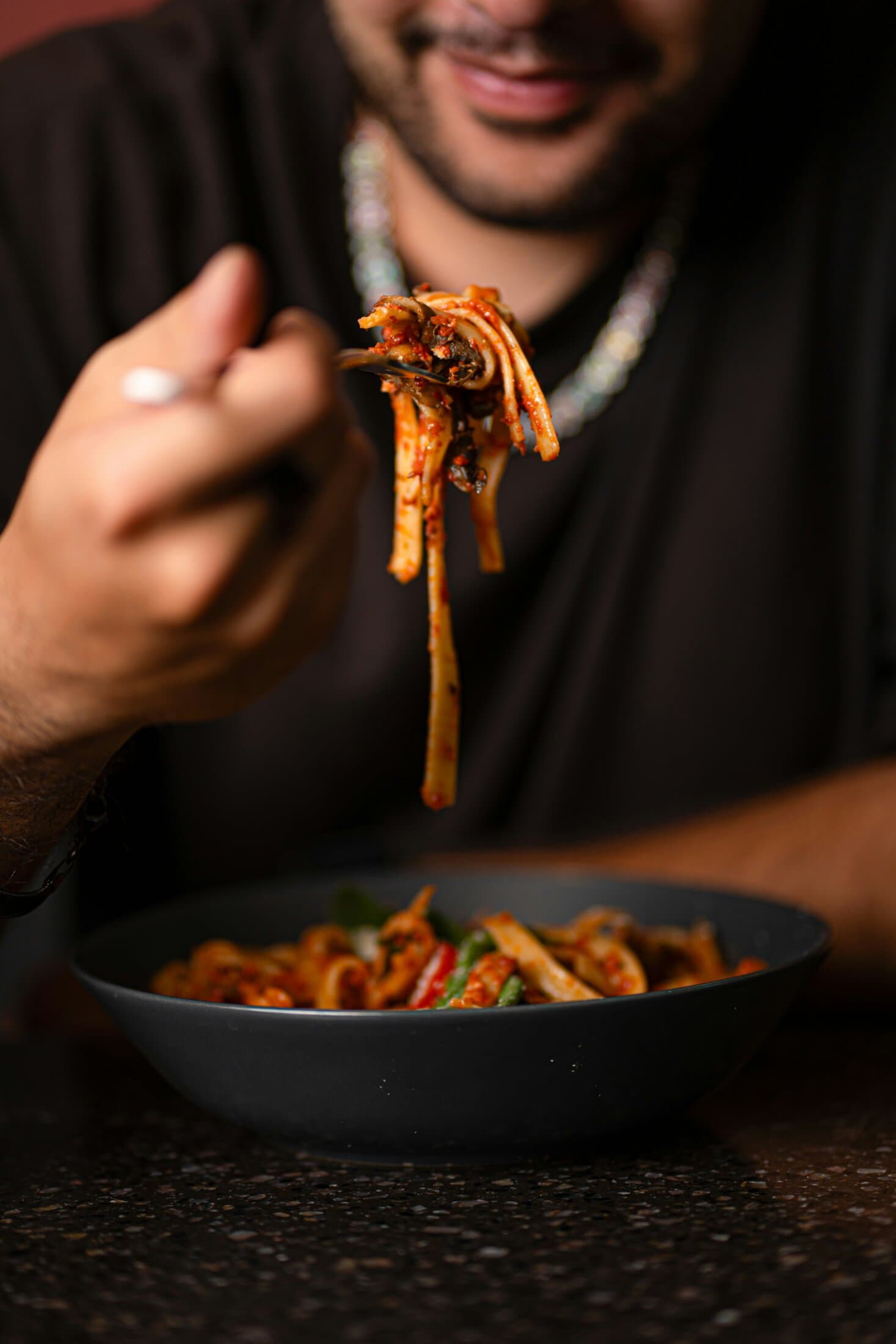 Man enjoying a bowl of spaghetti Bolognese with rich tomato sauce and herbs.